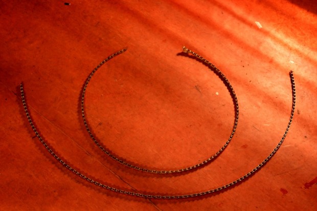 Eine Methode, um eine verschlissene Kette im ausgebauten Zustand zu erkennen: Die obere Kette lässt sich im Gegensatz zur unteren Kette seitwärts fast zu einem Ring biegen und ist verschlissen.