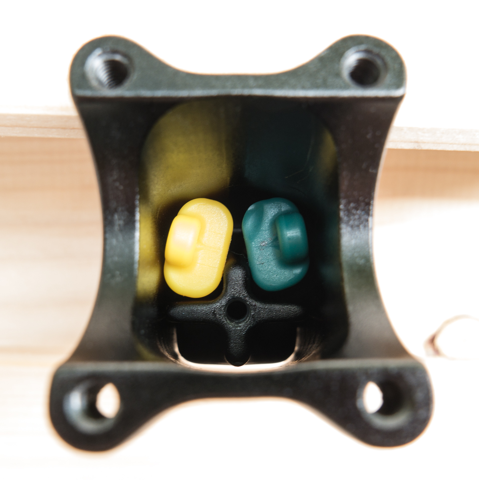 Die gewünschten Federelemente werden in den Vorbau eingesetzt. Das kreuzförmige Hebelelement bewegt sich bei Last nach oben und komprimiert die Elastomere. Die kleinen Ösen an den Elementen erlauben es, sie zum Wechsel aus dem Vorbau zu angeln, beispielsweise mithilfe eines Inbusschlüssels.