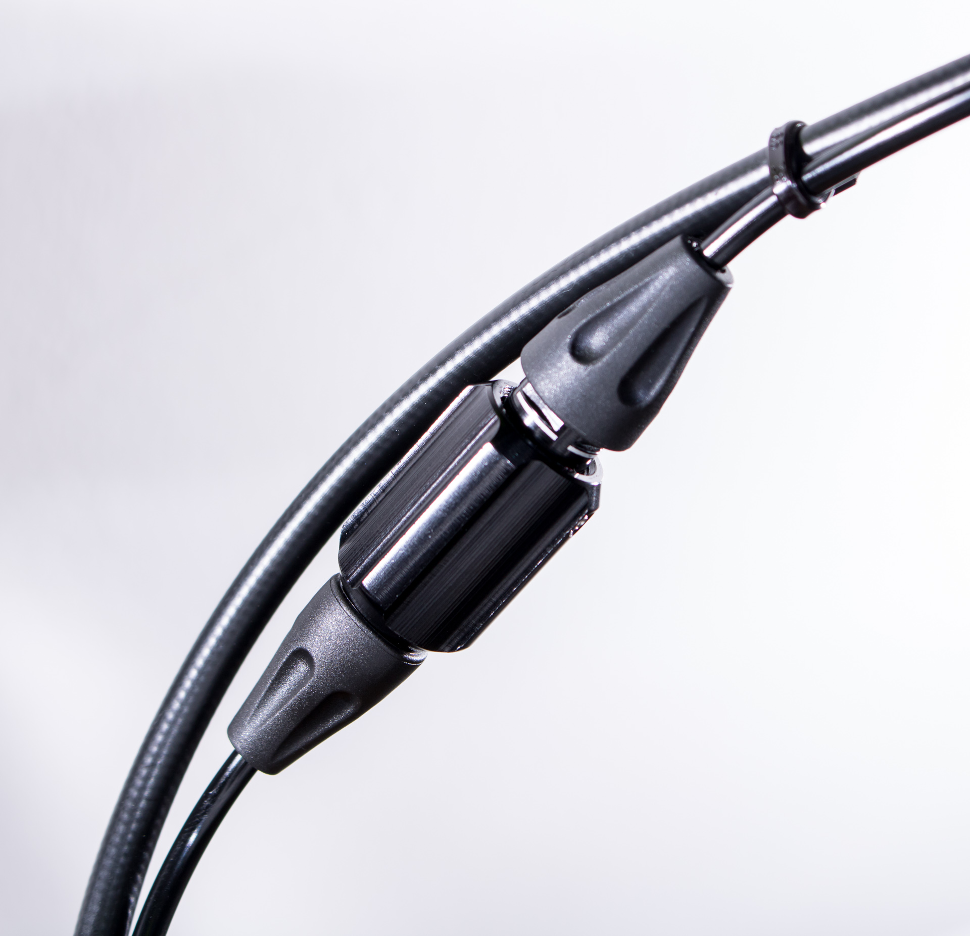 Der dicke Hydraulikschlauch durchmisst 5 mm und führt zu den Bremsen. Die Schläuche der Schaltung sind mit 3 mm deutlich schlanker. Im Bild außerdem zu sehen ist der "Pressure Point Adjuster", mit dem der Druckpunkt der Schaltung härter oder weicher eingestellt werden kann.